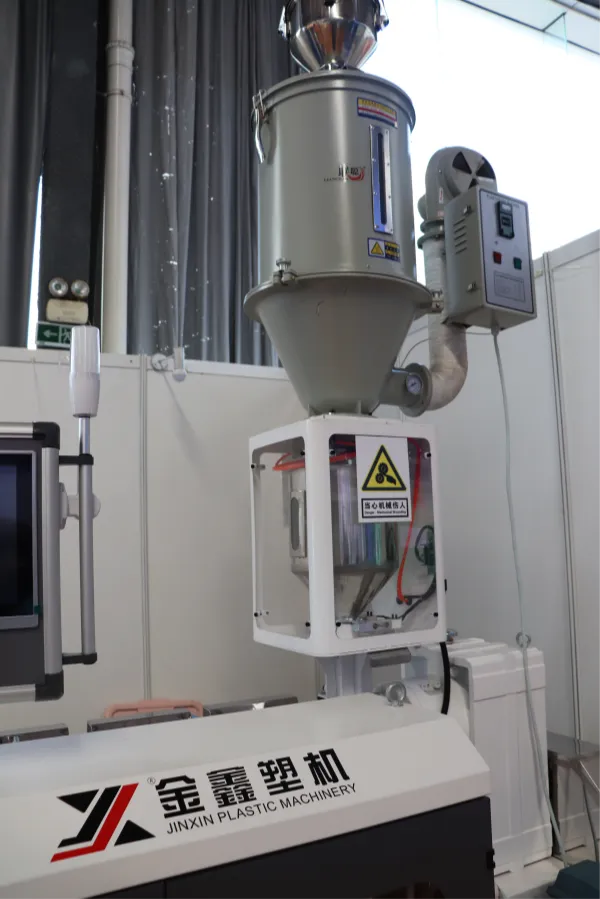 Extruder hopper feeding plastic resin into the barrel